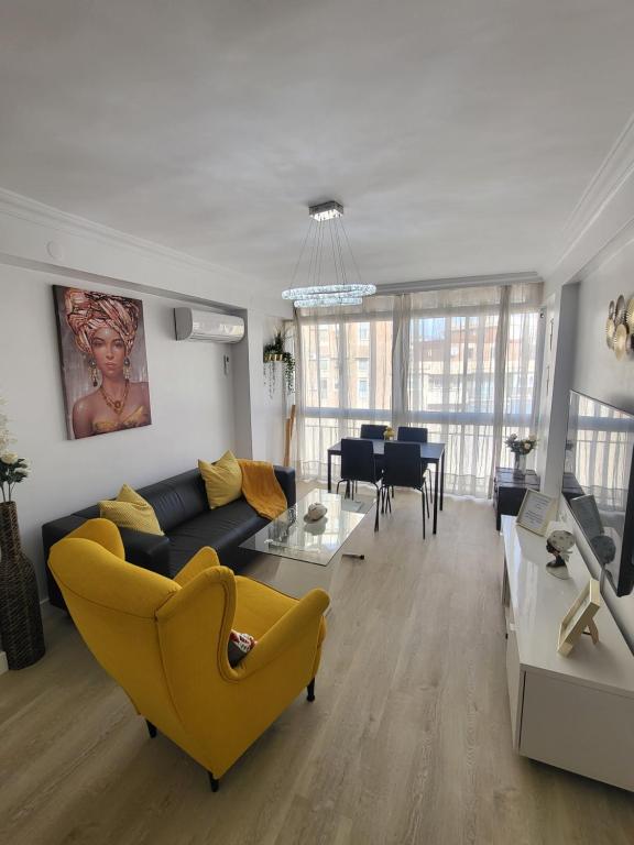 un soggiorno con divano giallo e una sala da pranzo di Appartement centre ville Malaga a Málaga