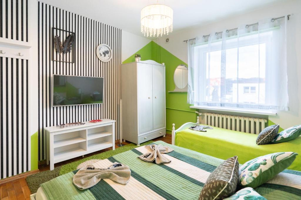 a childs bedroom with a green and white wall at Pokoje Goscinne Oliwia & Laura I in Rumia