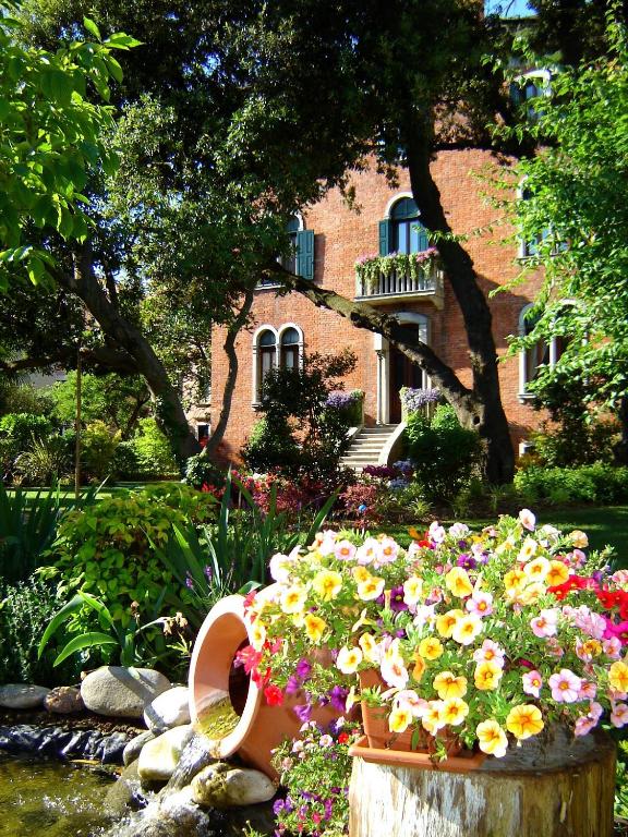 un jardin avec des fleurs devant un immeuble dans l'établissement B&B Villa Ines, sur le Lido de Venise
