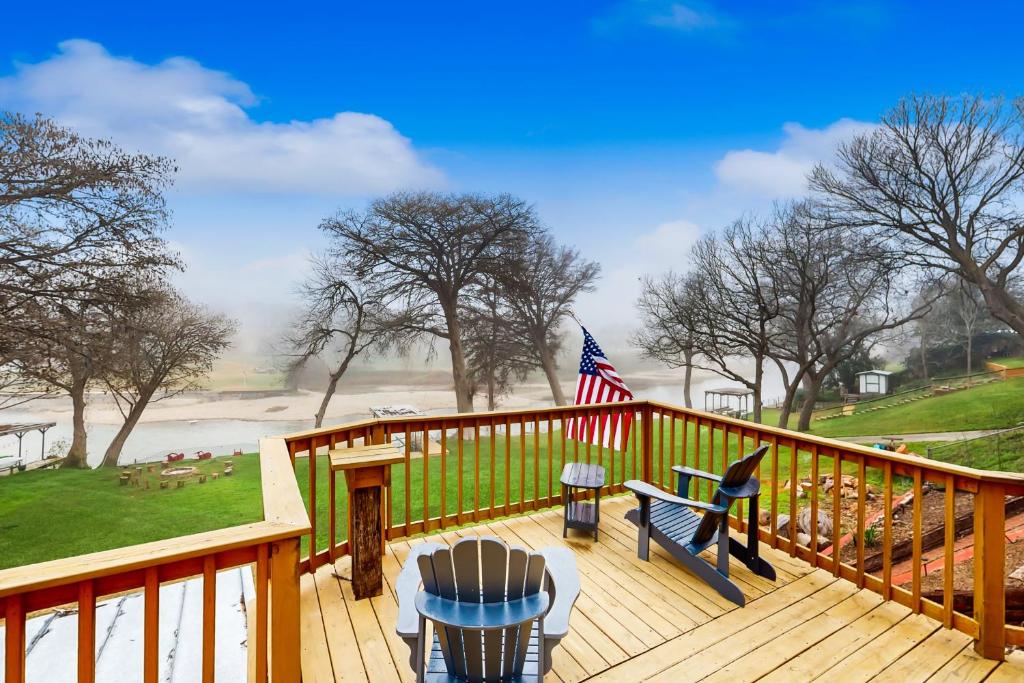 a deck with a table and chairs and an american flag at Waterside Haven in New Braunfels