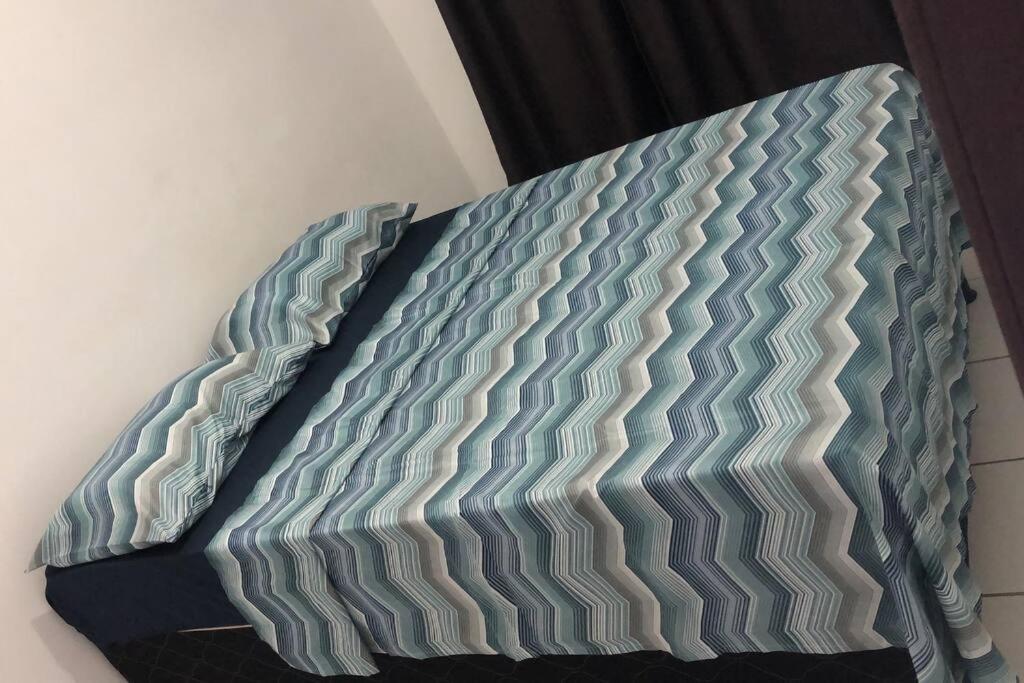 łóżko z niebieską i szarą narzutą w obiekcie Apartamento - Salvador BA w mieście Salvador