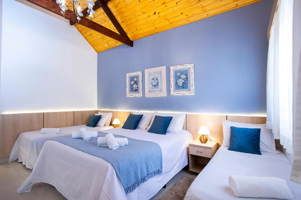 two beds in a room with blue walls at Pousada das Videiras in Monte Verde