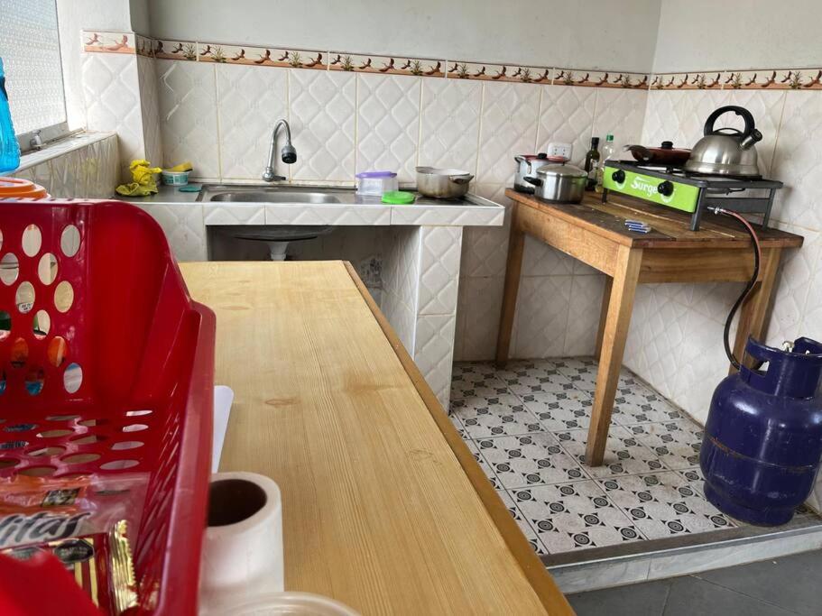 eine kleine Küche mit einem Tisch und einem Waschbecken in der Unterkunft Yachanapaq Wasi II in Huanta