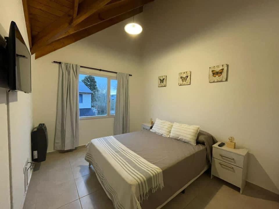 sypialnia z łóżkiem i dużym oknem w obiekcie Ciruelo Tempo w mieście Esquel