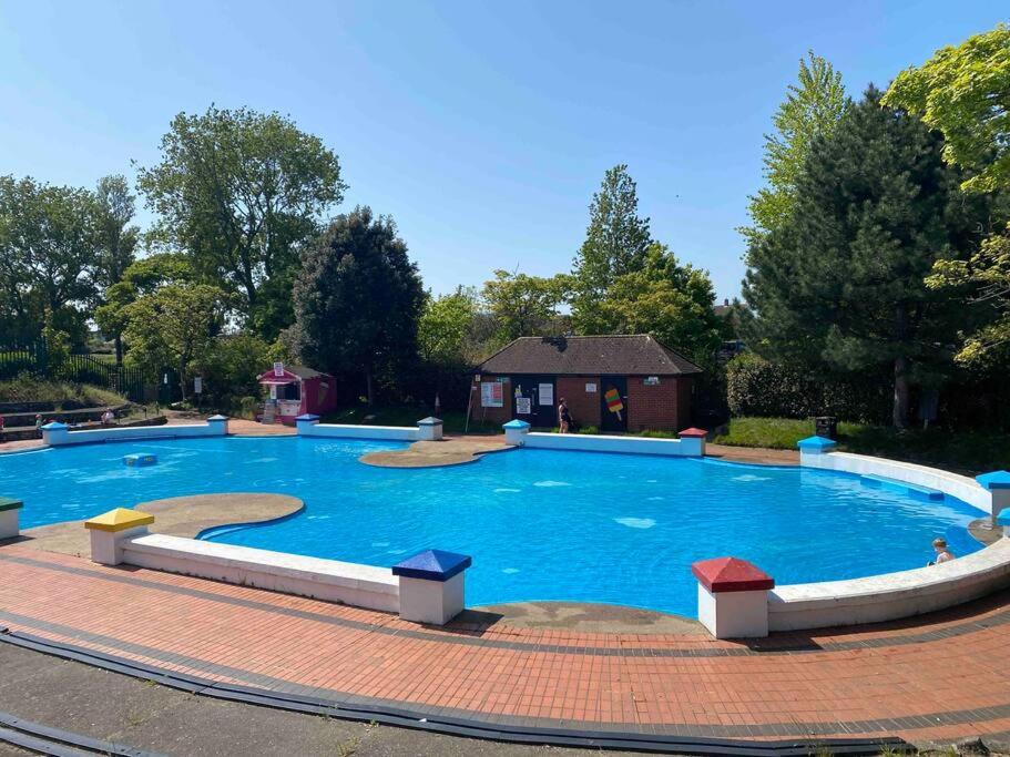a large blue swimming pool on a brick ground at Sea view Cottage in Cleethorpes