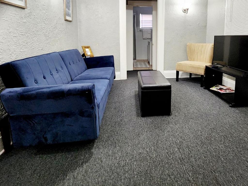 uma sala de estar com um sofá azul e uma cadeira em TWO BEDROOM HOME IN BEAUTIFUL DOWNTOWN LAKELAND em Lakeland