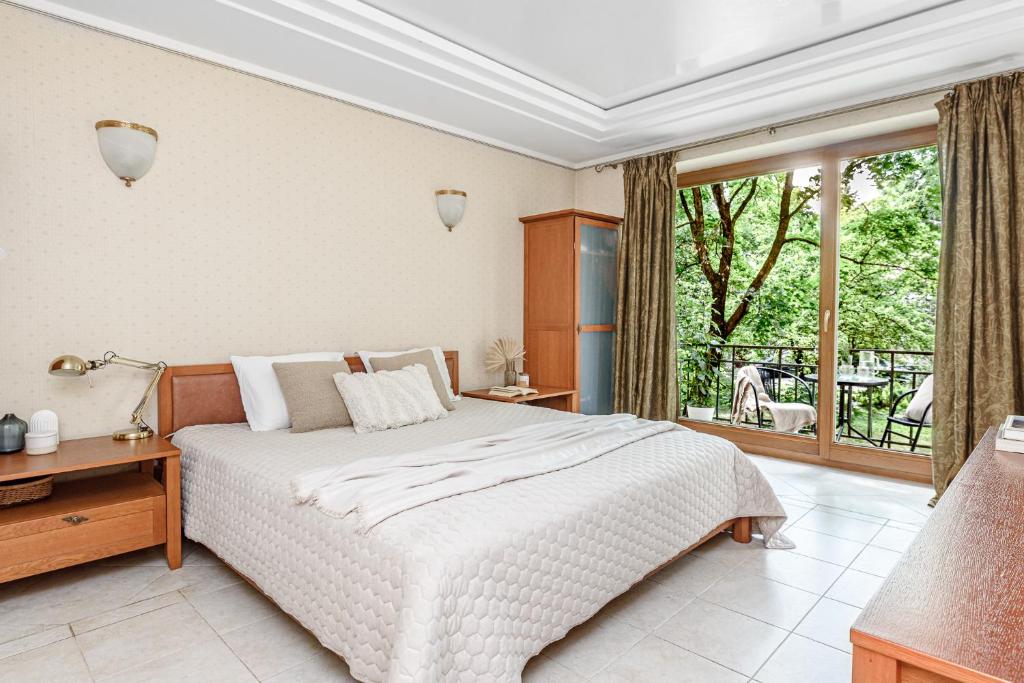 una camera con un letto bianco e una grande finestra di Jacuzzi apartments SELF CHECK-IN 24/7 by H&H a Vilnius