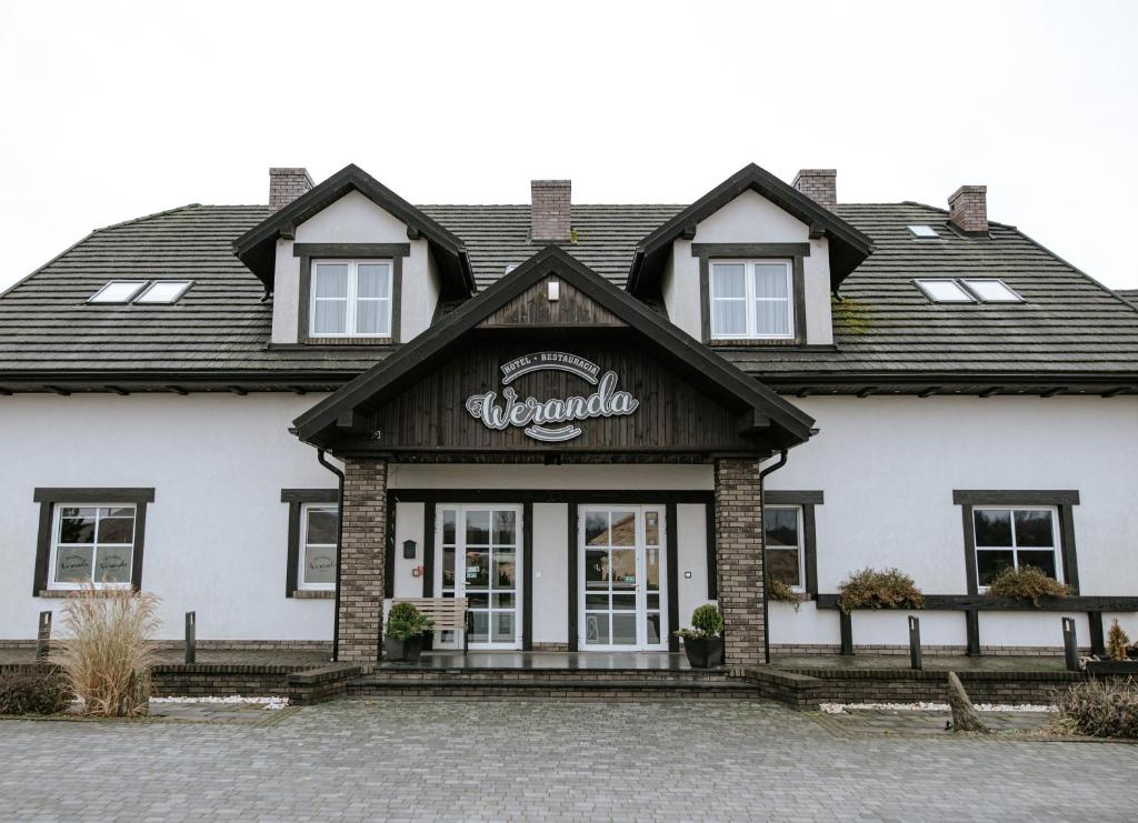 a building with a sign on the front of it at Hotel Weranda Łopuszno in Łopuszno