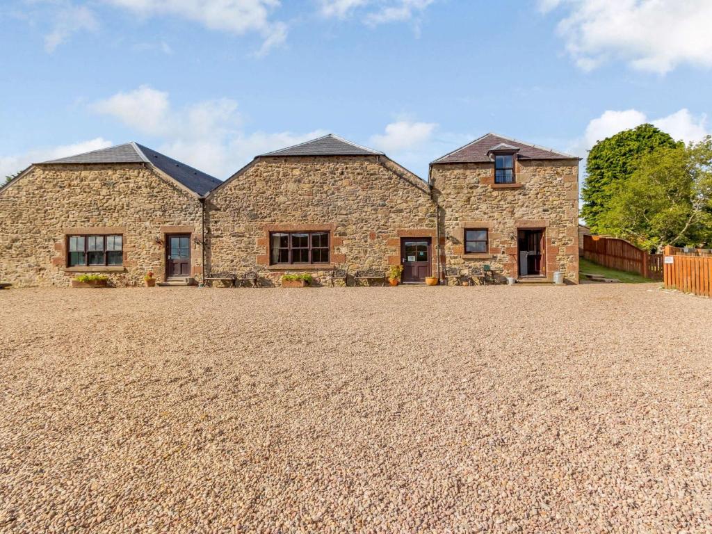 a large stone house on a gravel driveway at 8 Bed in Pearsie CA261 in Kirriemuir