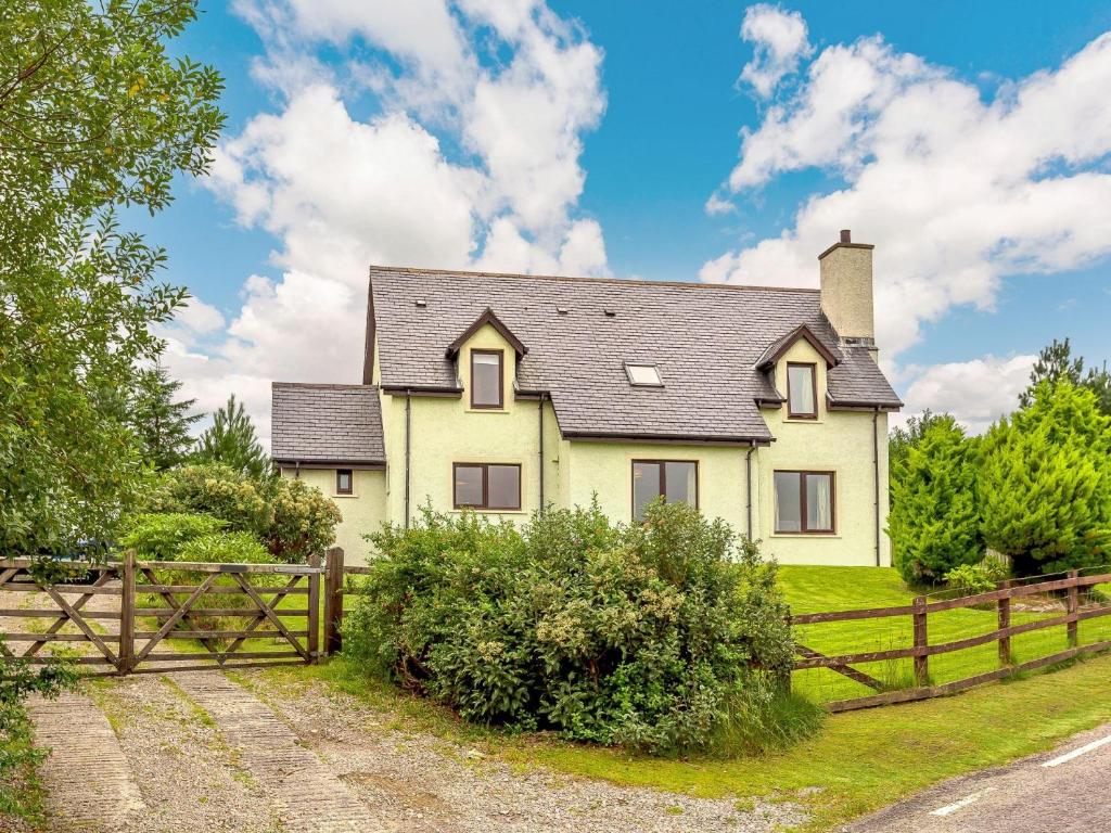 a yellow house with a wooden fence at 4 Bed in Badachro CA390 in Strath