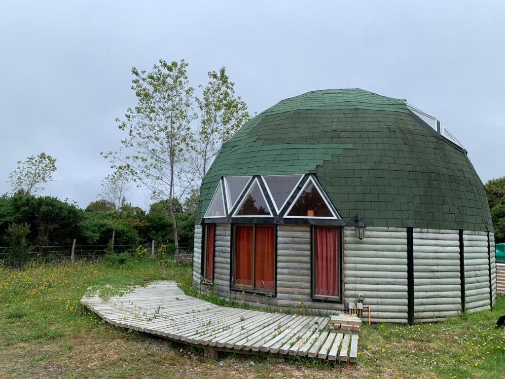 une petite maison avec un dôme vert sur un champ dans l'établissement Domo Malinche, à Lechagua