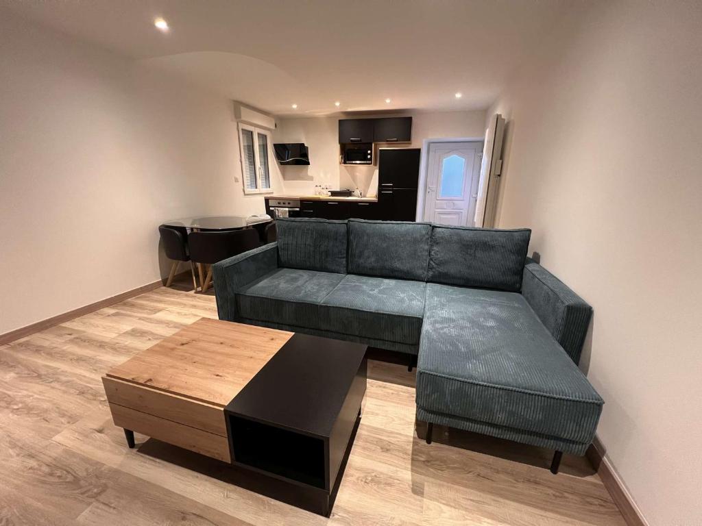 ein Wohnzimmer mit einem Sofa und einem Tisch in der Unterkunft Appartement Cosy Gîte Le Marmont in Châtillon-sur-Seine