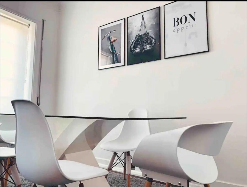 une salle à manger avec une table en verre et des chaises blanches dans l'établissement Self-Check in Sunny & Charming Apt, à Coimbra