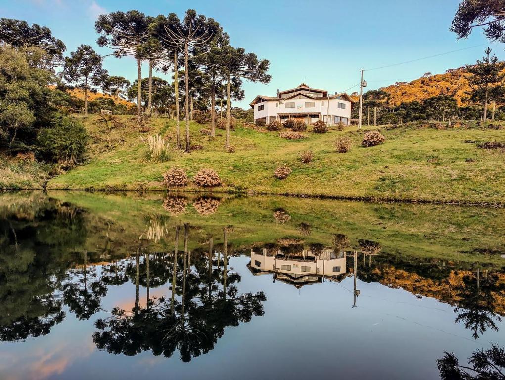 una casa sentada en la cima de una colina junto a un lago en Hibisco Home Hotel, en Urubici