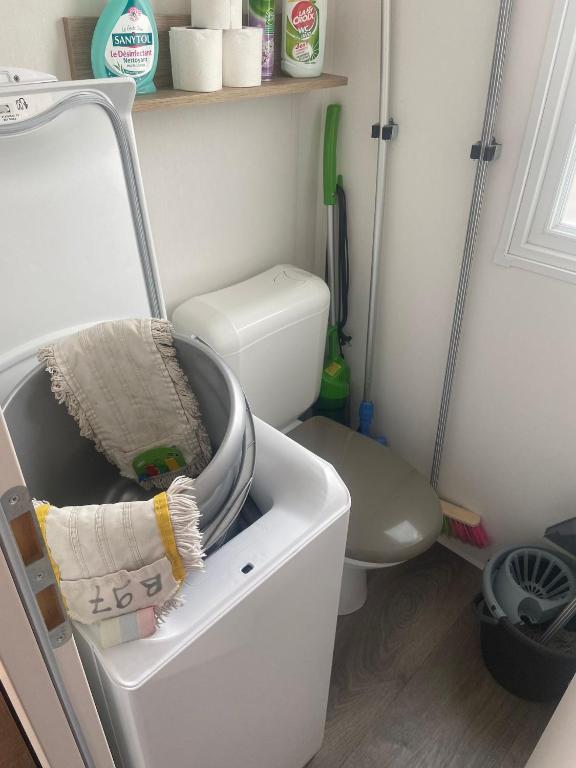 a bathroom with a toilet and a white refrigerator at Mobilhome 4/6 personnes in Valras-Plage