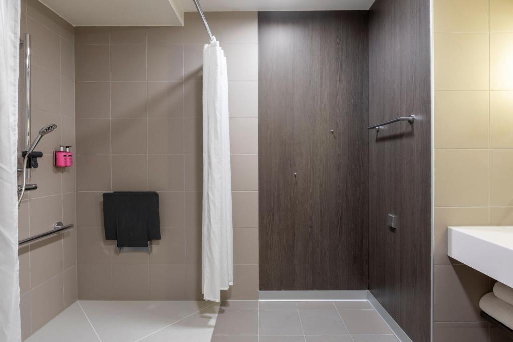 a bathroom with a shower and a sink at Moxy Aberdeen Airport in Dyce