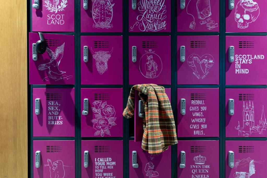 a wall of pink posters with a shirt on it at Moxy Aberdeen Airport in Dyce