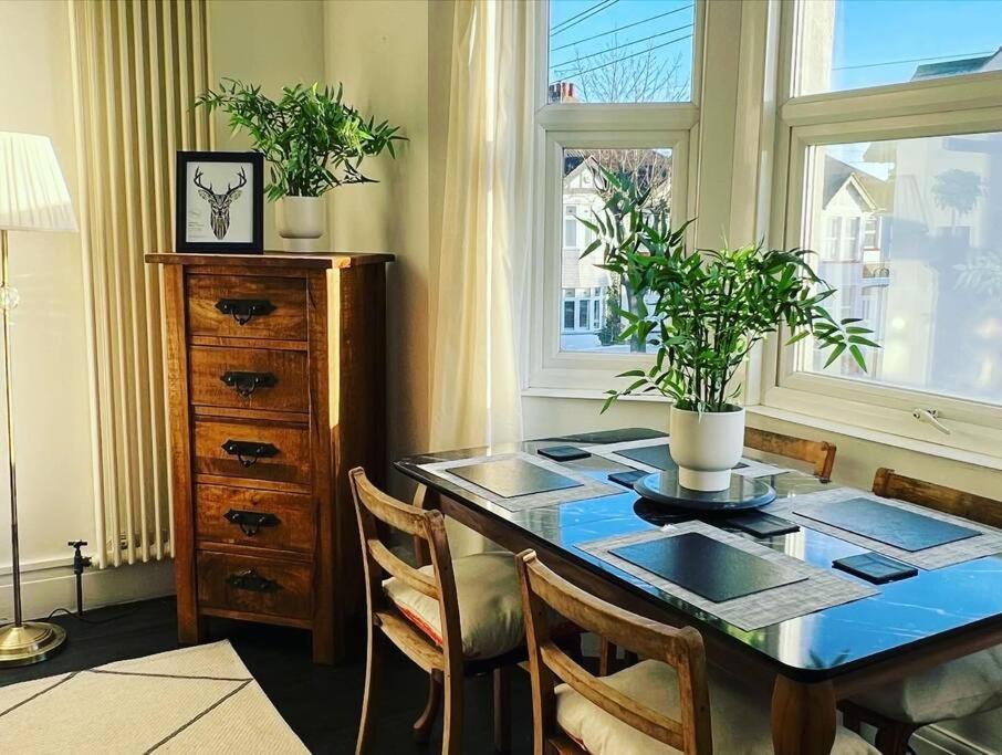 comedor con mesa, sillas y ventana en Hill Grove 2 Bedroom Apartment en Southend-on-Sea