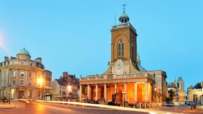 een oud gebouw met een klokkentoren op een straat bij Northampton Central Oasis in Northampton