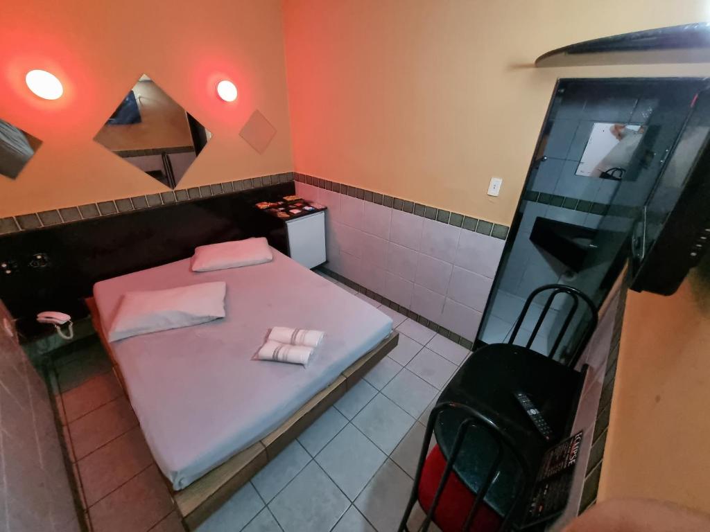 a bathroom with a pink bed and a mirror at Eclipse Motel in Recife