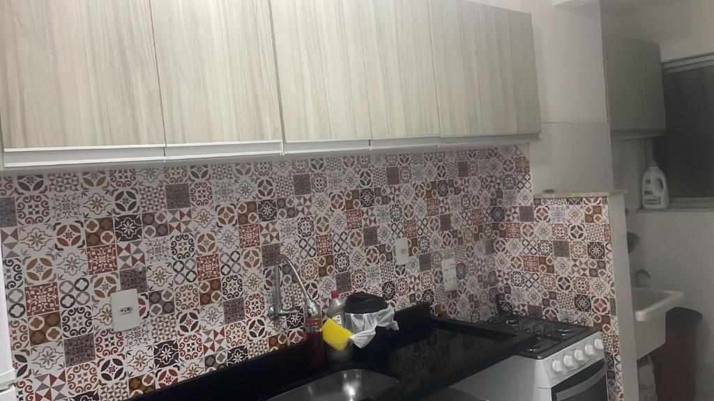 a kitchen with red and white tiles on the wall at Apartamento tupã in Propriá