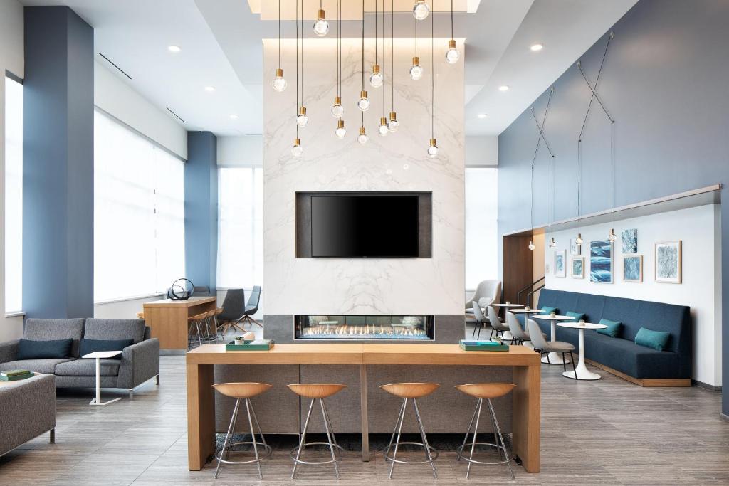 a lobby with a fireplace and a tv and chairs at Element Minneapolis Downtown North Loop in Minneapolis