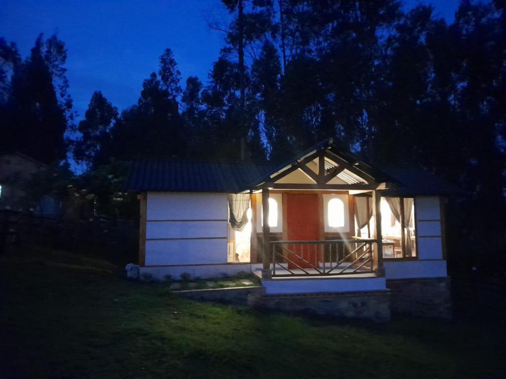 a small cabin with a red door at night at Cabaña Zeus en Villas de San Felipe in Oicatá