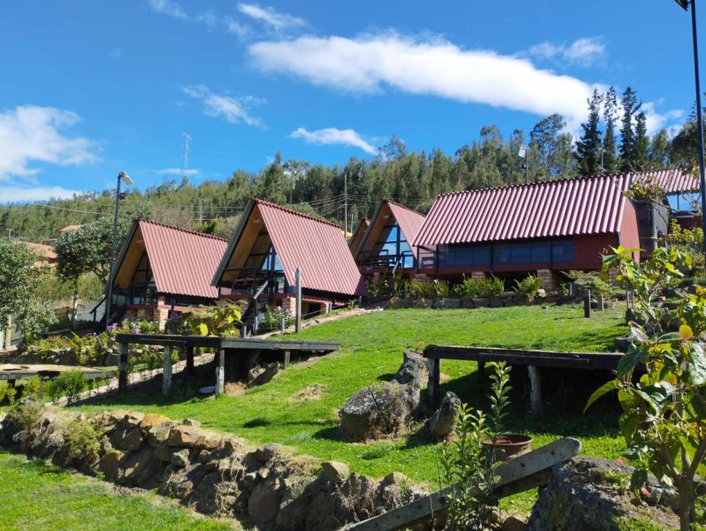 un grupo de cabañas en un campo con césped en Hospedaje Villa Rosita Suesca, en Suesca