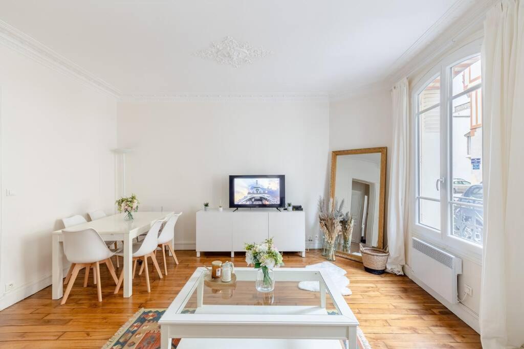 ein weißes Wohnzimmer mit einem Tisch und einem Esszimmer in der Unterkunft BOULOGNE-PORTE D'AUTEUIL ROLAND GARROS TOURISME in Boulogne-Billancourt