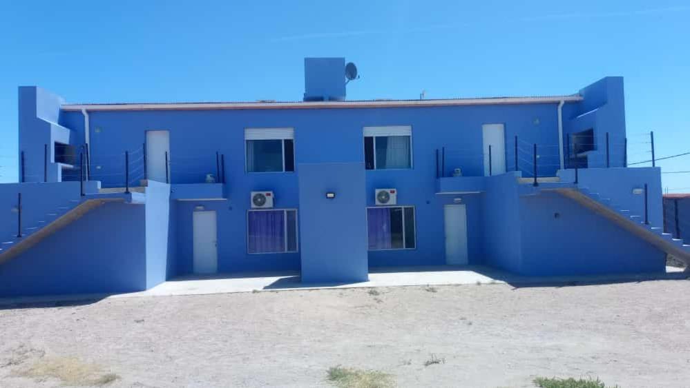 a blue building with a blue door in front of it at Complejo El Descanso in San Antonio Este