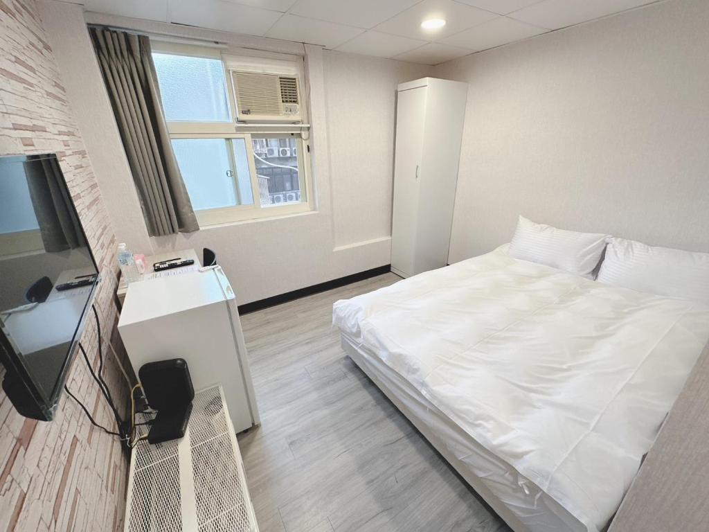 Postel nebo postele na pokoji v ubytování 新獅城商務旅館New Lion City Hotel