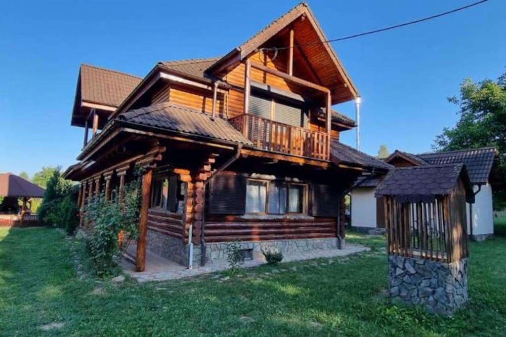 a log house with a porch and a balcony at Amazing villa in the mountains with Jacuzzi in Vistisoara