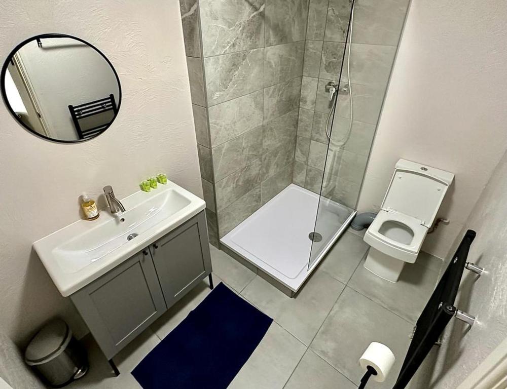 a bathroom with a shower and a sink and a toilet at Flat 3 Stay In Aldgate Apartments in London