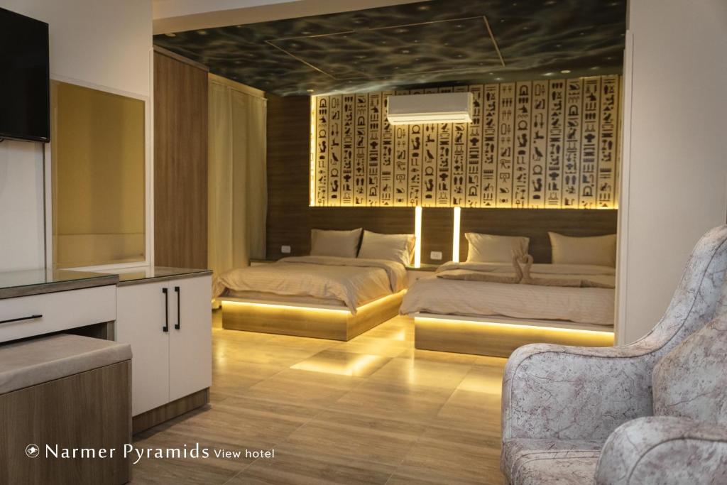 - une chambre avec 2 lits, une télévision et un canapé dans l'établissement Narmer Pyramids View, au Caire