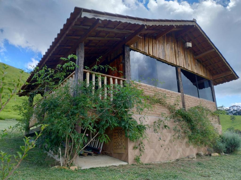 a house in the middle of a field at Pousada Rancho da Montanha in Visconde De Maua