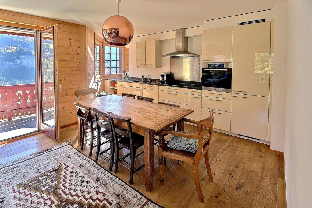 eine Küche mit einem Holztisch und Stühlen im Zimmer in der Unterkunft Duplex Wchimney Overlooking The Village in Champéry