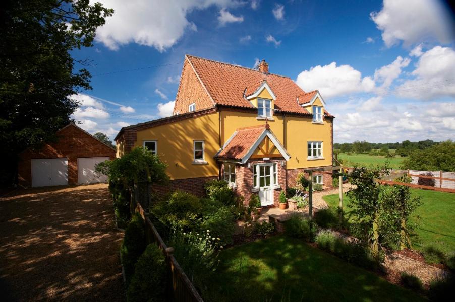 una grande casa gialla con tetto rosso di Sunset House Bed and Breakfast a East Harling