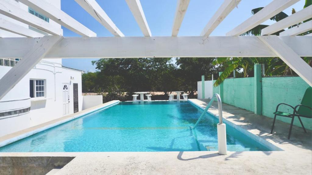 ein großer Pool mit einer weißen Pergola in der Unterkunft See Belize TRANQUIL Sea View Studio with Balcony, Infinity Pool & Overwater Deck in Belize City