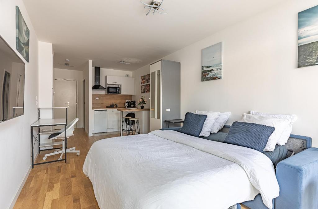 1 Schlafzimmer mit einem großen Bett und einer Küche in der Unterkunft Studio Neuf proche Parc de Sceaux / RER in Sceaux