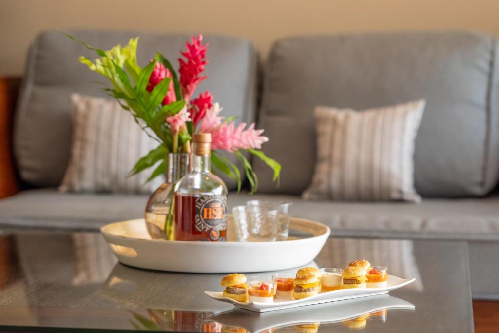 uma mesa de centro com uma garrafa de vinho e alguns snacks em Physacap Suites & Villas em Le François