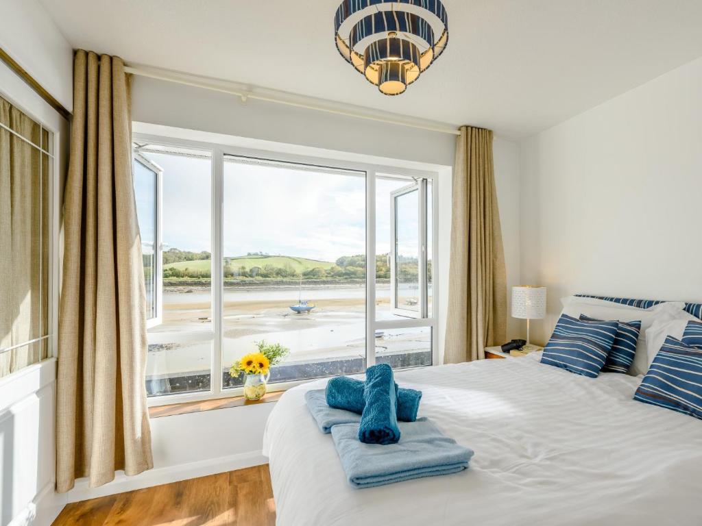 a bedroom with a large window with a view of the beach at 2 Bed in Bideford 79441 in Bideford