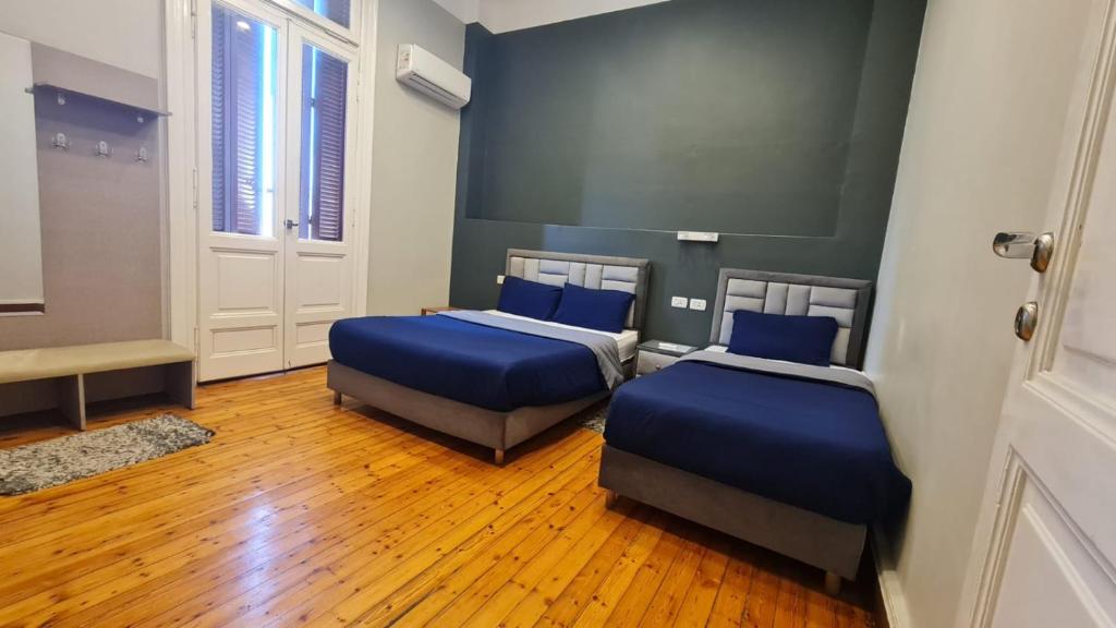a room with two beds with blue pillows in it at Cairo Hub in Cairo