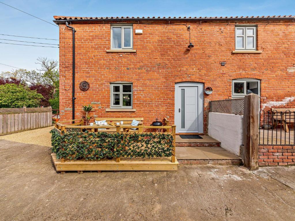 a brick house with a fence and a patio at 2 Bed in Northallerton 90795 in Great Langton