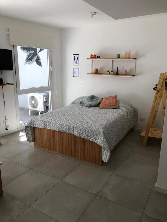 a bedroom with a bed in a room with a window at Palermo Apartamento Buenos Aires in Buenos Aires