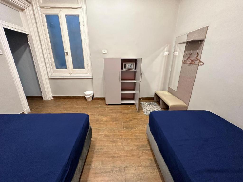 a bedroom with two blue beds in a room at Cairo Hub in Cairo
