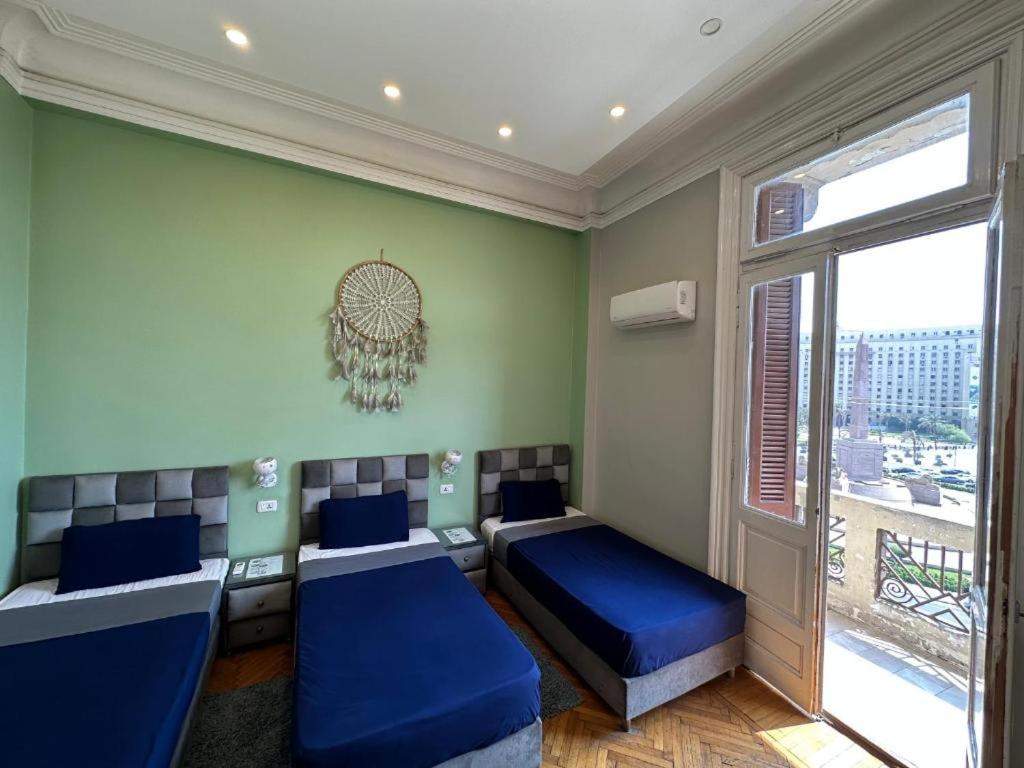 a bedroom with two beds and a window at Cairo Hub in Cairo