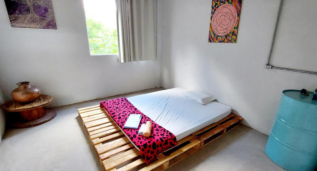 um pequeno quarto com uma cama e um telemóvel em Pousada Vila da Serra - Quarto Cantinho do Sossego em Nova Lima