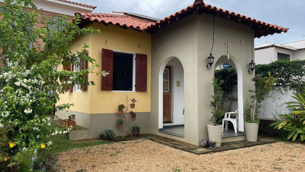 a yellow house with an arched entry way at Chalé Arcos do Sol - Carrancas in Carrancas