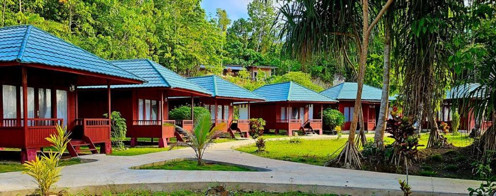 szereg czerwonych domów z niebieskimi dachami w obiekcie Raflow Resort Raja Ampat w mieście Tapokreng