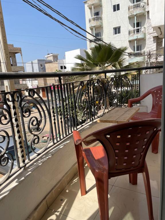 a balcony with a table and chair on a balcony at One love in Dakar